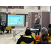 A man reading off of the projector screen to the audience.