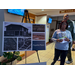 A woman standing next to a diagram for Fayette Place.