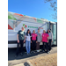 Six women taking a group photo in front of a Durham Tech van.