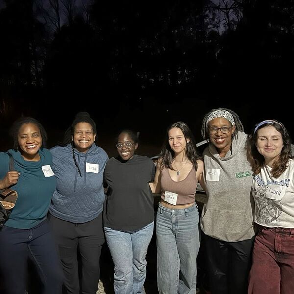 WeStillSkating1.jpg Six women taking a group photo outside at night.