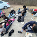 A group of children sitting on the ground putting on knee and elbow pads.
