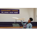 A student flying a toy plane in the gym of Lakeview School. We Roar With Pride.