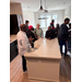 A group of people standing and talking around a kitchen island.