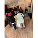 Eight people standing around a kitchen island.