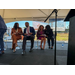 Four people sitting and talking on stage under a tent.