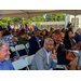 A group of people sitting in chairs under a tent.