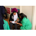A woman kneeling to help someone fill out paperwork.