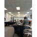 Individuals with laptops sitting around tables. 
