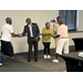  Five individuals smiling and shaking hands with each other. 