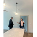  A woman and man speak by the kitchen counter in the Vanguard Apartments. 