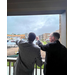  Two men stand on a balcony and point out into the distance. 