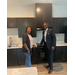  A man and woman smile in the kitchen of the Vanguard Apartments. 
