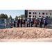  Eleven individuals wearing hard hats and each shoveling a pile of dirt for the groundbreaking of Dillard Apartments. 
