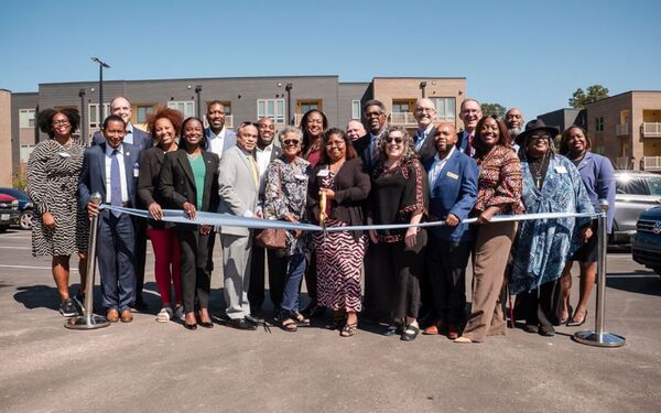 VanguardandDillardStreetAparments3.jpg A big group of individuals smiling behind a ceremonial ribbon.