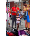  A little girl picking out a backpack while two women smile and watch. 