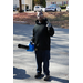  A man holding a leaf blower in one had and holding up a piece sign with the other. 