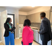  Three individuals looking at a kitchen. 