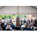  A gentleman standing behind a podium speaking to a crowd. 